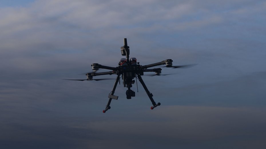 The VECTIS Recon M2 in flight against a cloudy sky during a reconnaissance and surveillance mission.